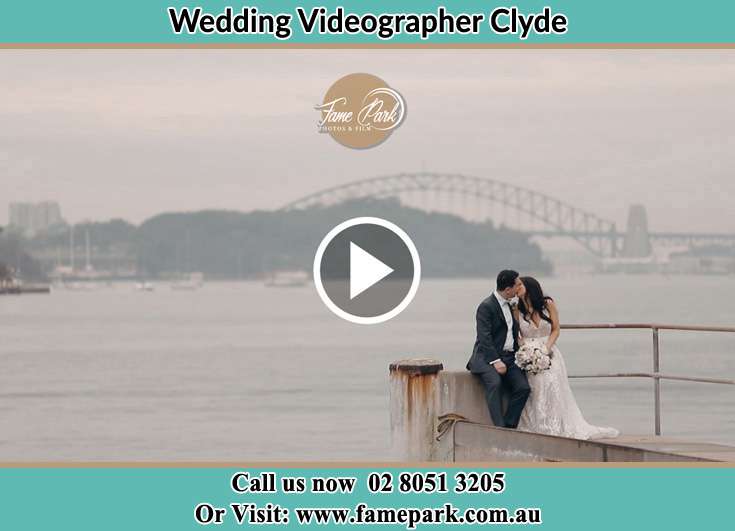 Bride and Groom kissed while sitting near the shore Clyde NSW 2142