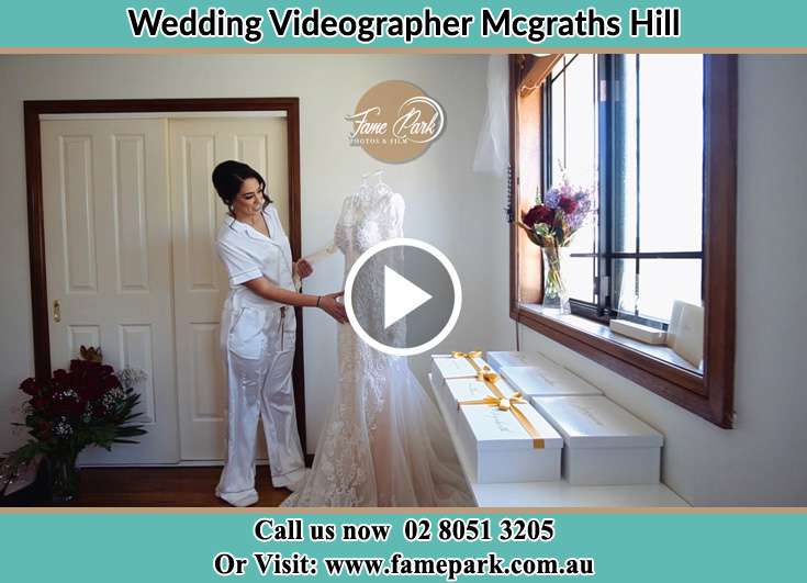 Bride looking at her wedding gown Mcgraths Hill NSW 2756