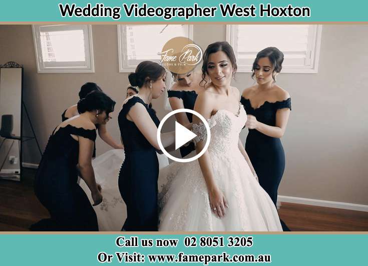 The bridesmaids helped the Bride in fixing her bridal gown West Hoxton NSW 2171