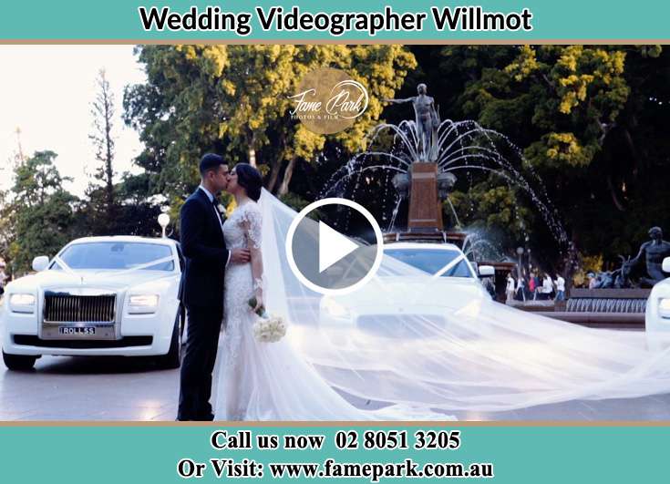 The newlyweds kissing near the bridal car Willmot NSW 2770